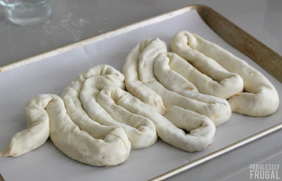 Placing the stuffed dough to look like intestines on a baking sheet