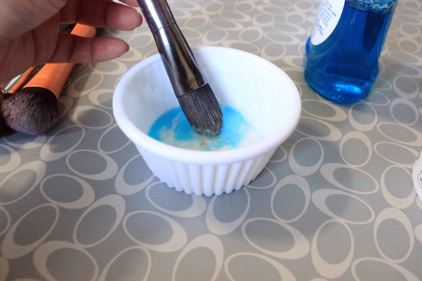 Swirling a makeup brush in the DIY makeup brush cleaner