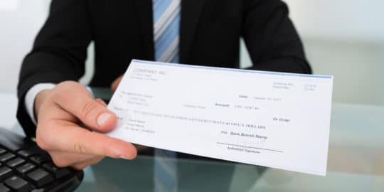 Guy holding a cheque