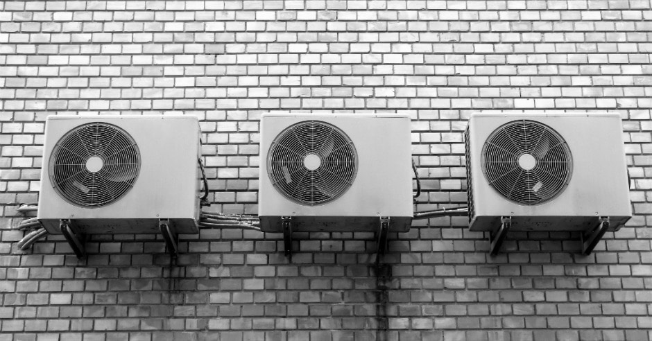 Three air conditioning units on a wall