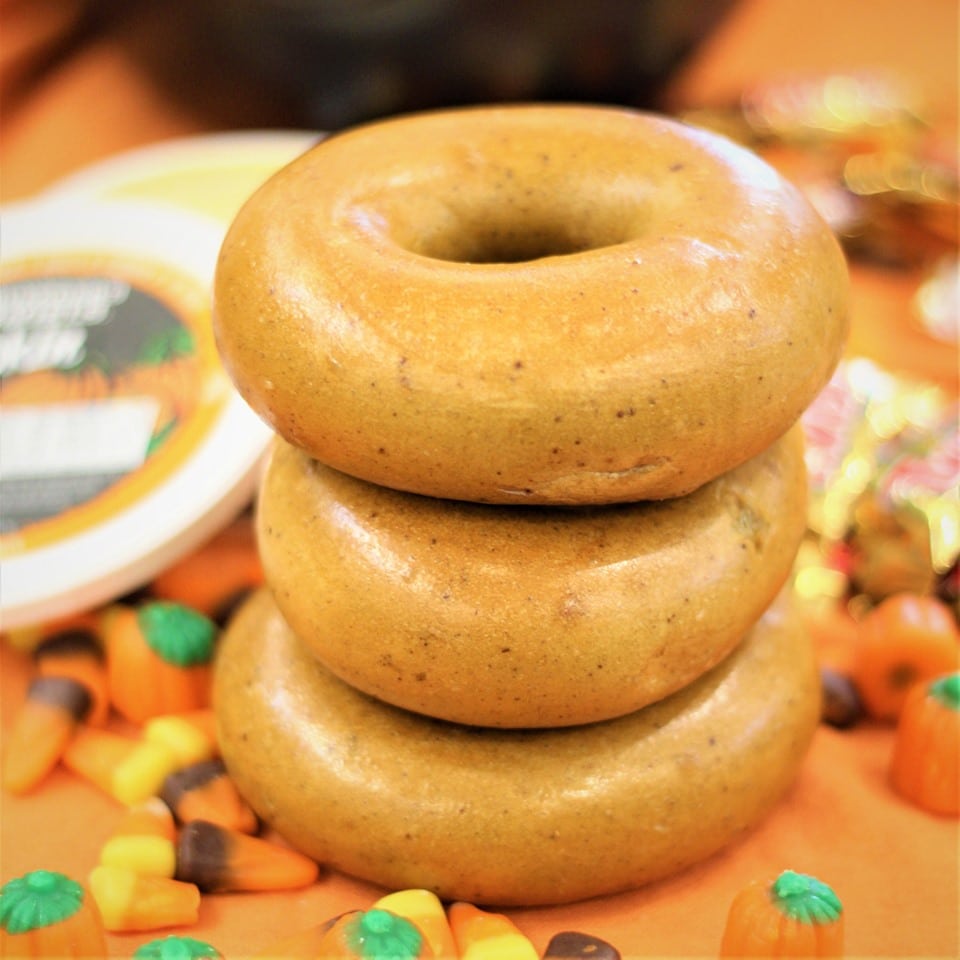 Three brueggers bagels on orange counter with Halloween candy