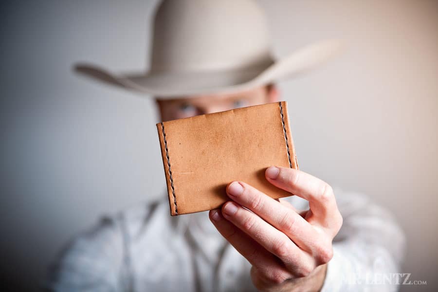 Man holding leather wallet up to camera