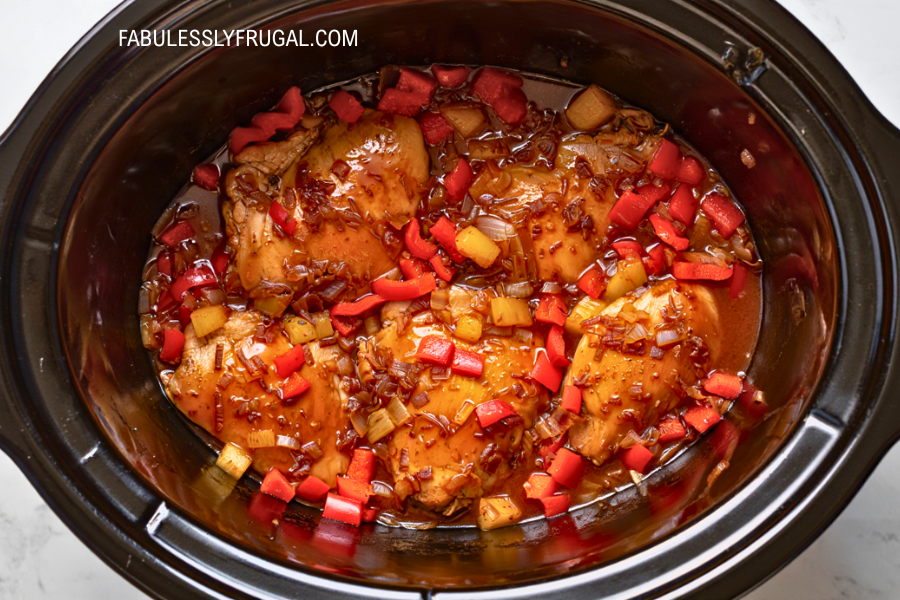 Crockpot Hawaiian chicken simmering with thickened sauce – fabulesslyfrugal.com branding