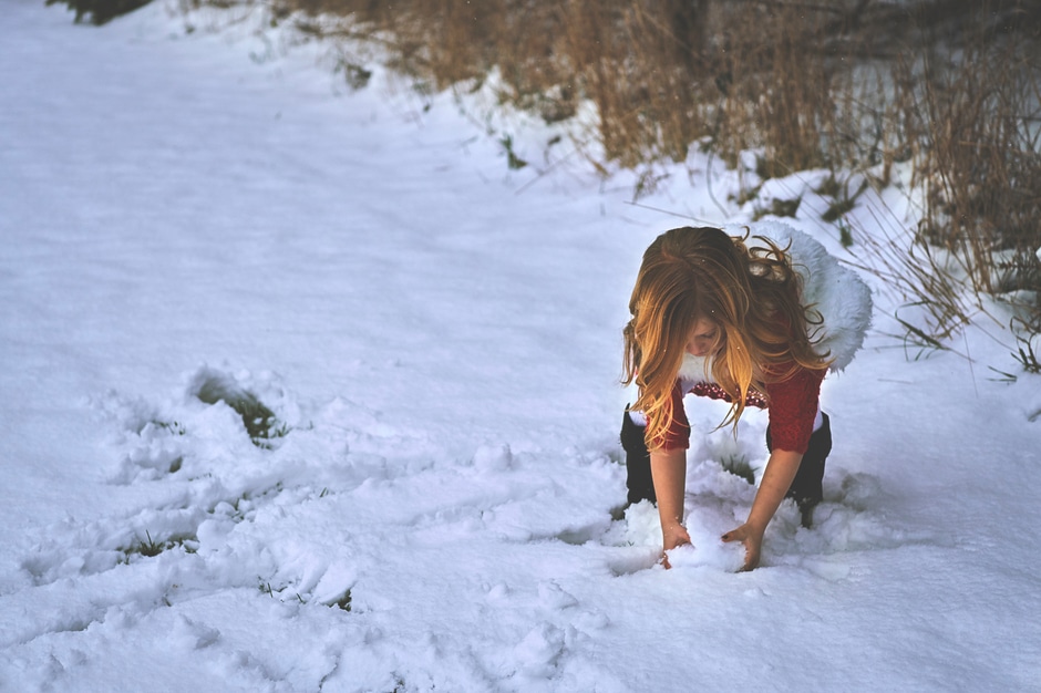 Young girl making a snowball