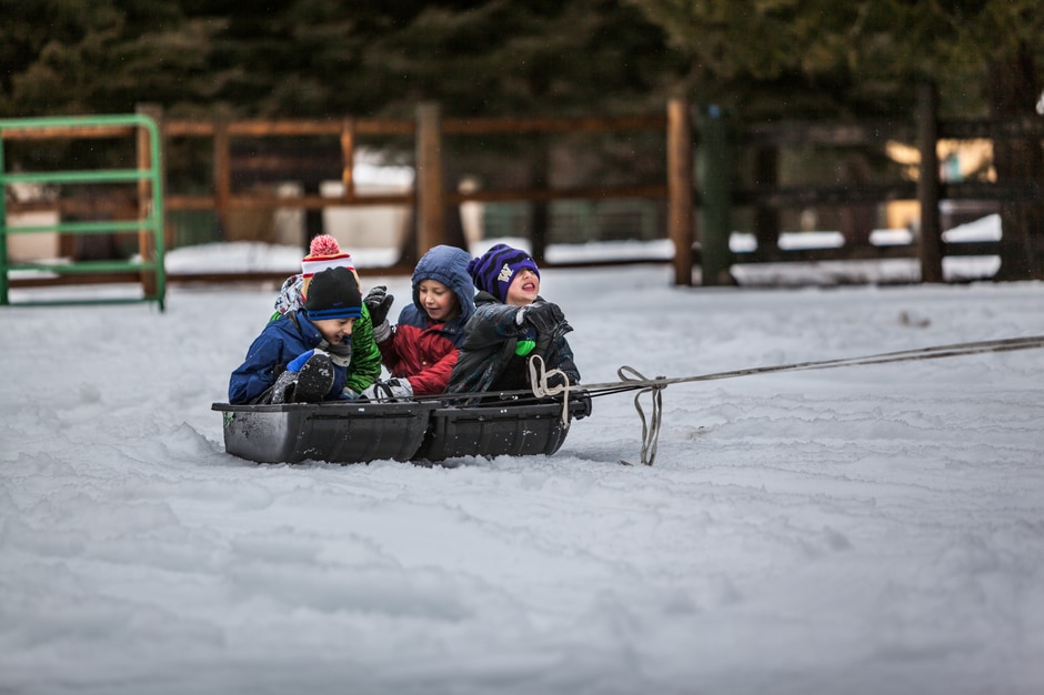 Three kids getting pulled on a sled