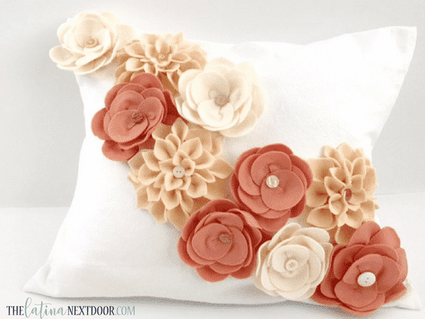 Several differently designed felt flowers on a pillow