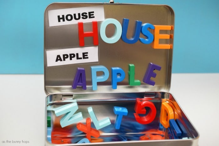 Metal lunch box with the words house and apple spelled on it 