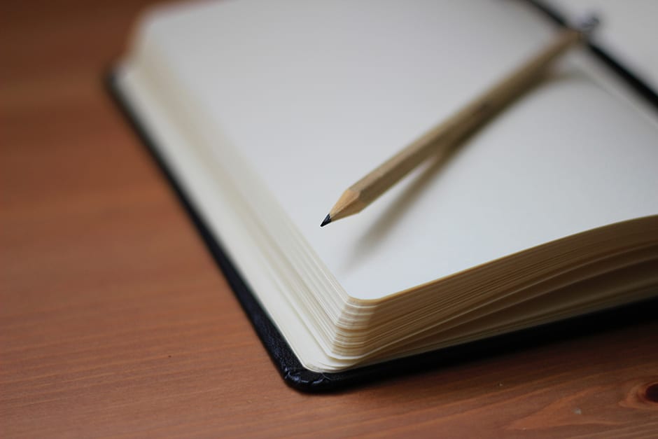 Close up notebook with a pencil on top