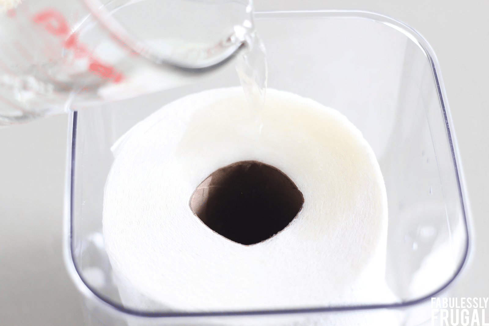 Pouring the DIY cleaning solution over paper towels