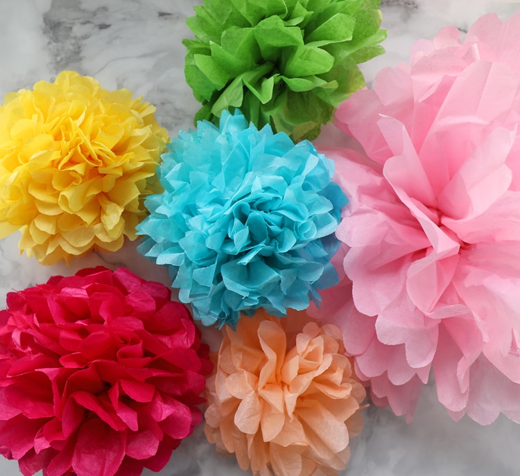 5 different colored and sized tissue paper flowers