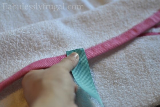 Placing ribbon on baby towel