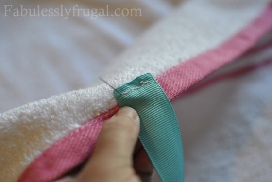 Sewing ribbon onto baby towel with neck strap