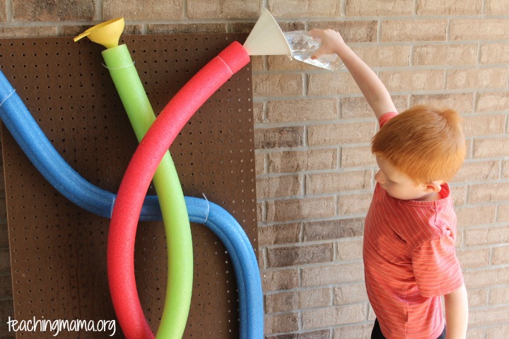 Child pouring water into pool noodle