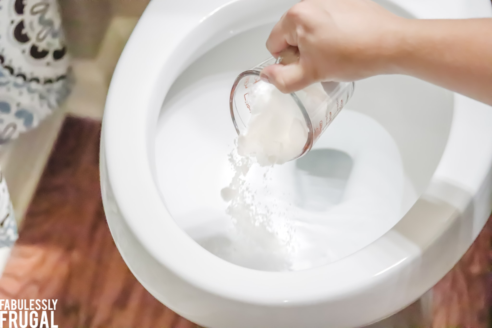 Pouring baking soda into toilet