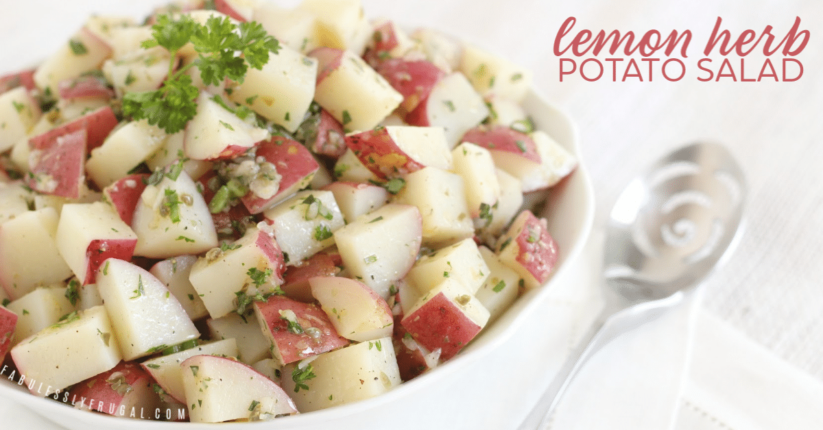 Bowl of red potato salad with green herbs on top