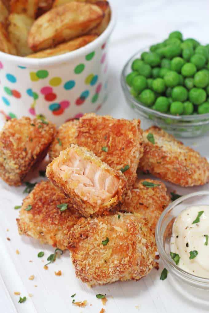 Pile of salmon nuggets with fries and peas