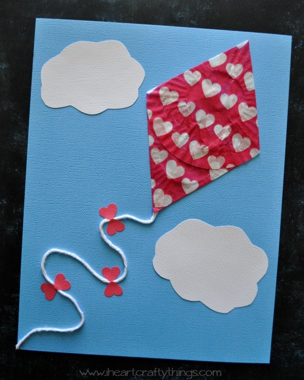 Red cupcake liner kite with cloudy construction paper background