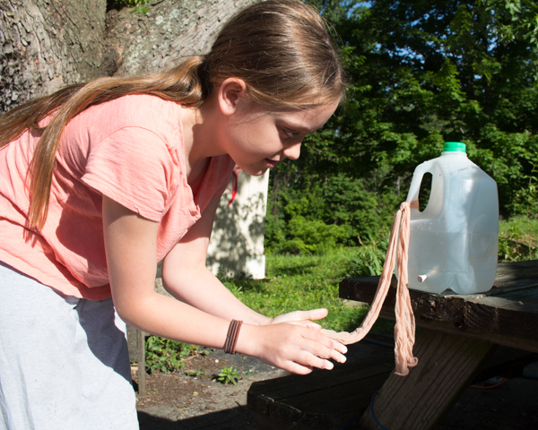 Girl using DIY handwashing station