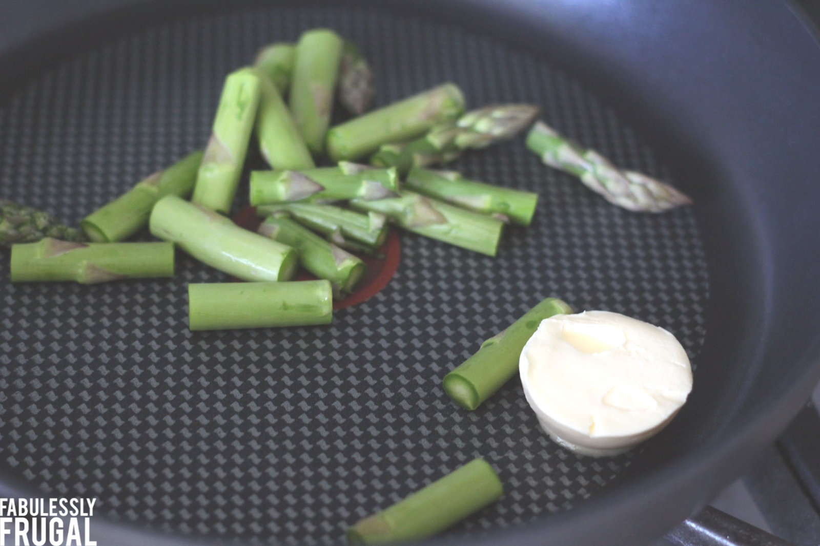 Cooking chopped asparagus on skillet with butter