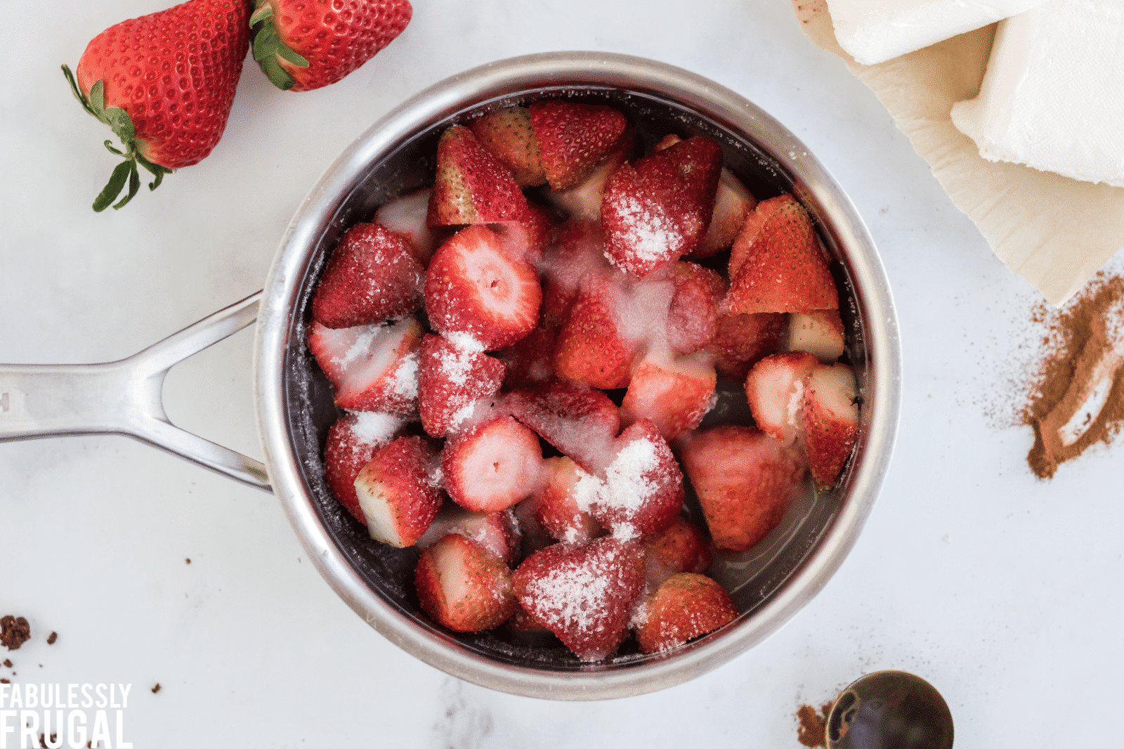 Strawberries, sugar, and water in saucepan