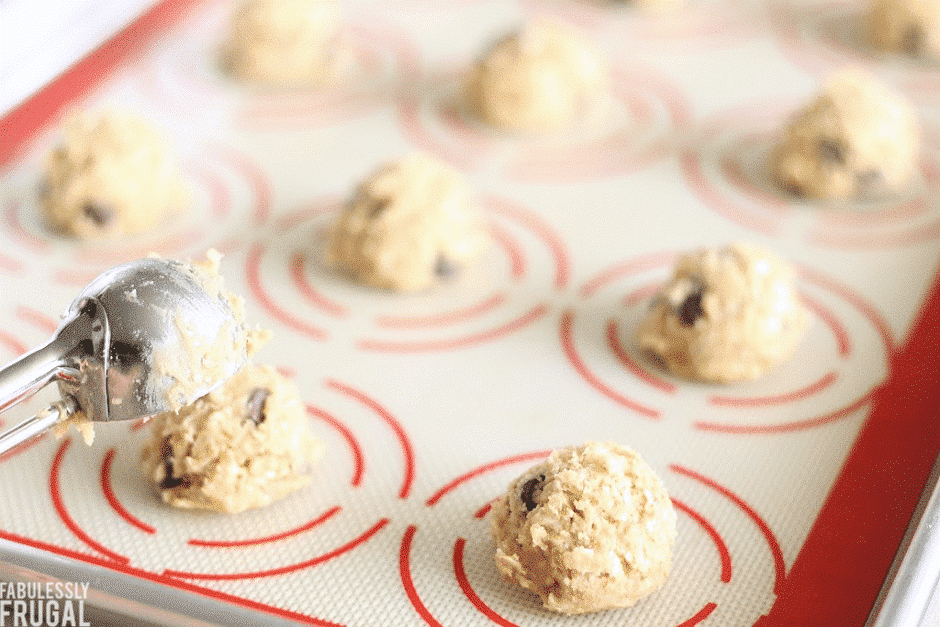 Scooping the oatmeal chocolate chip cookies onto a baking sheet