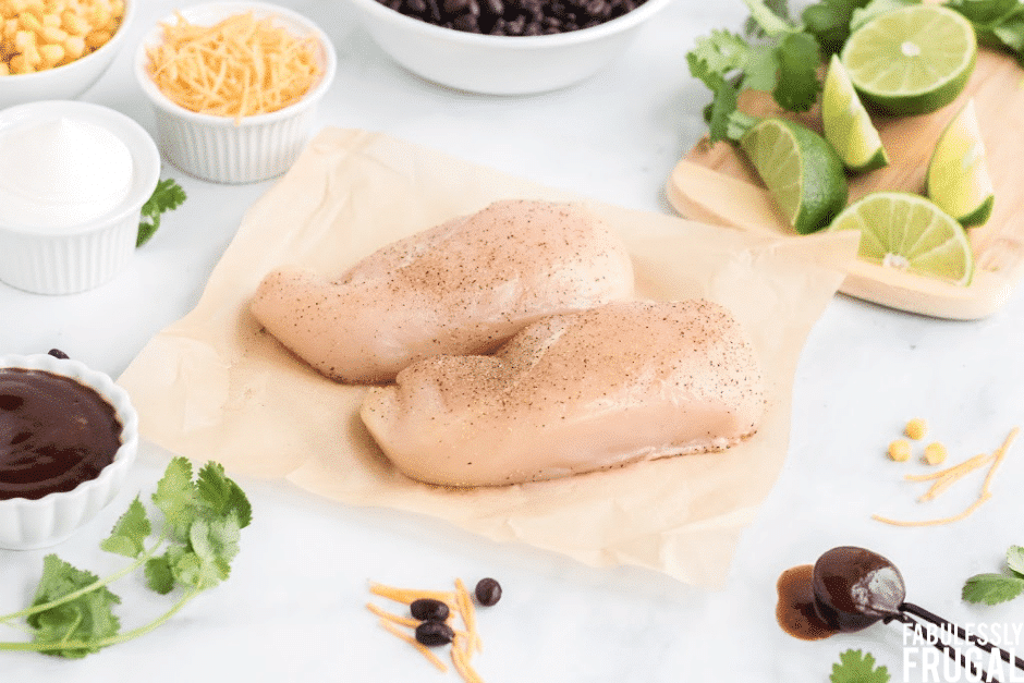 Raw chicken breasts on parchment paper