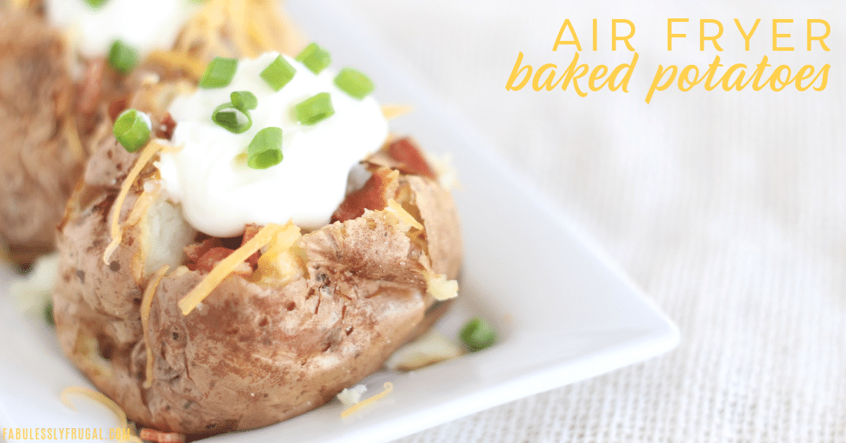 Air fryer baked potato topped with sour cream, cheese, bacon, and green onions