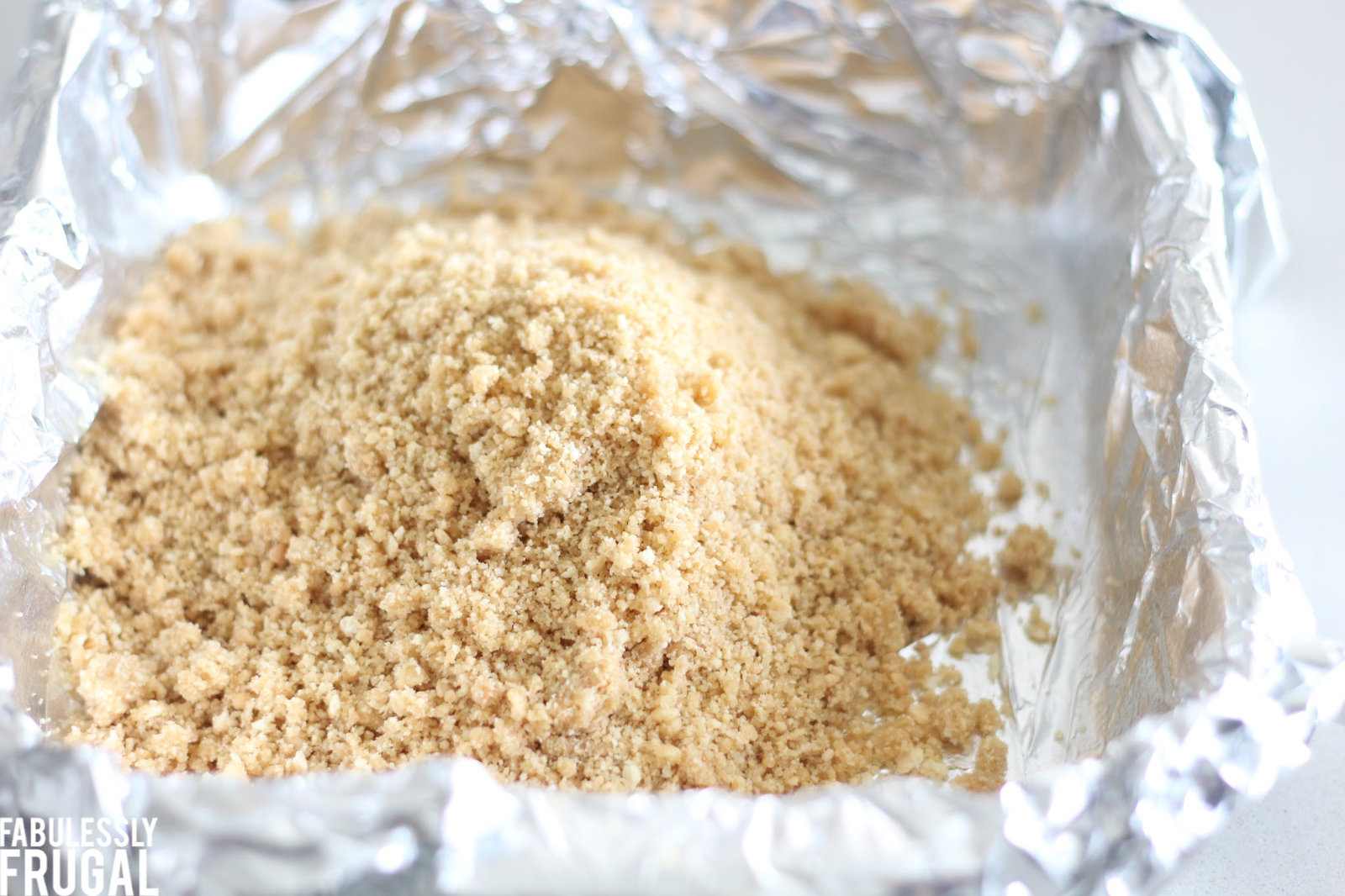 Animal cracker crust mixture in baking pan