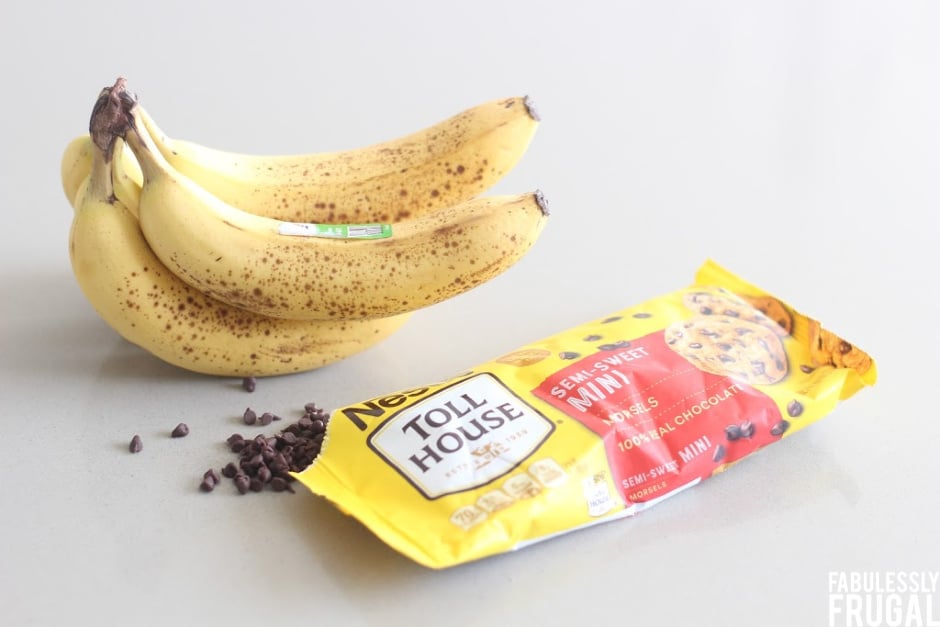 Bundle of bananas next to a package on opened chocolate chips