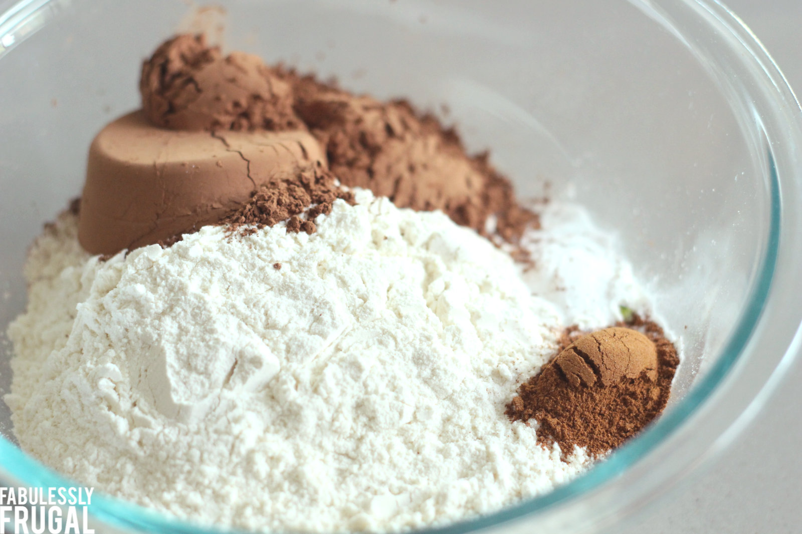 Bowl of flour, cinnamon, salt, baking soda, and cocoa powder unmixed