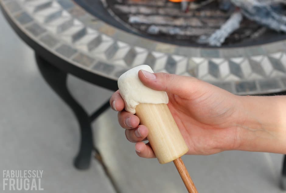 Spreading biscuit dough onto wooden roasting stick