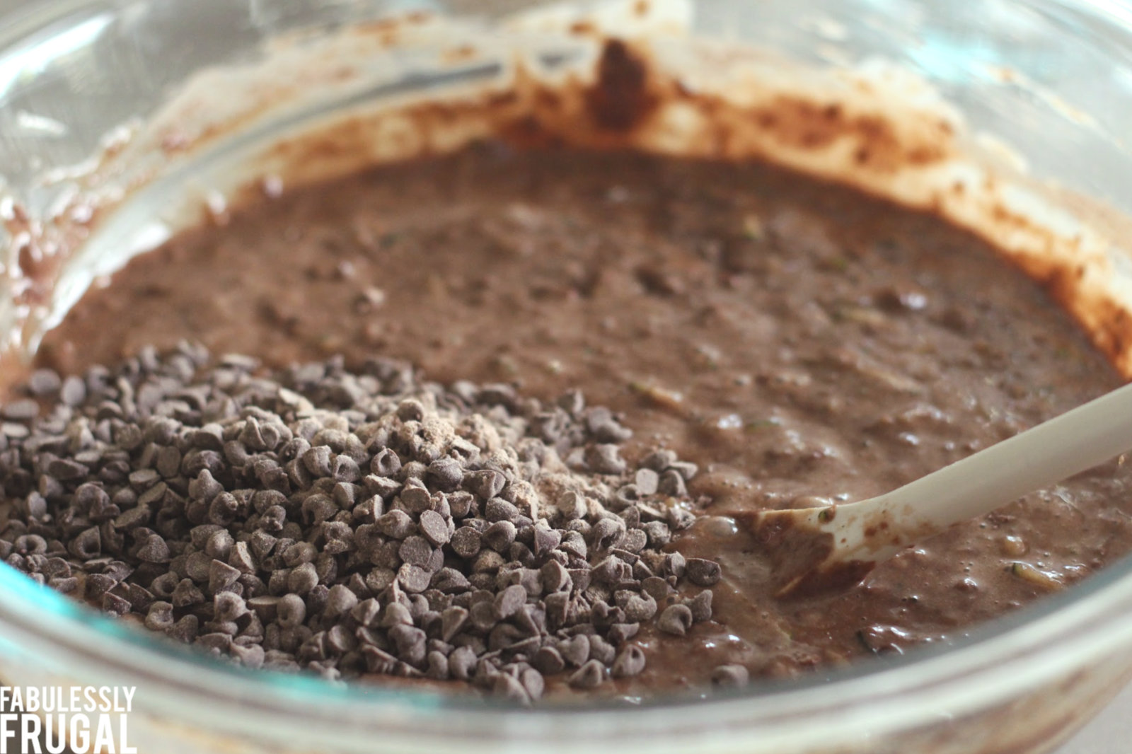 Mixing chocolate chips into chocolate zucchini batter