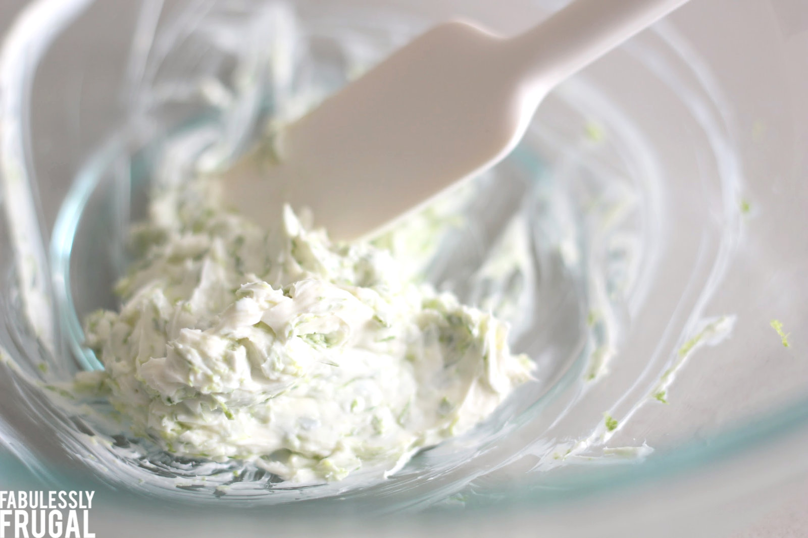 Mixing cream cheese lime zest and salt with rubber spatula