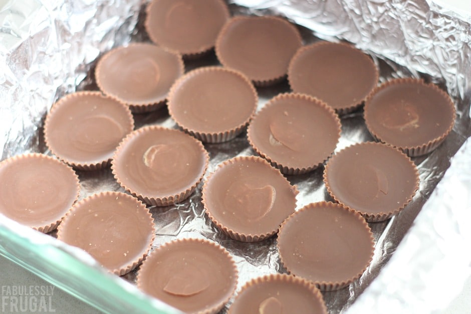 Reeses' peanut butter cups layering a baking dish on aluminum foil