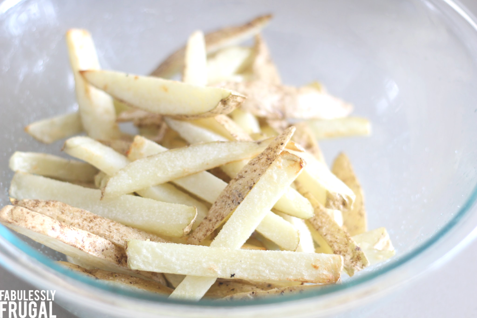 Tossing french fries with oil and salt, blond color 