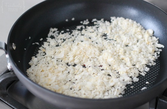 unsweetened coconut flakes getting toasted in a skillet for the healthy no bake energy bites
