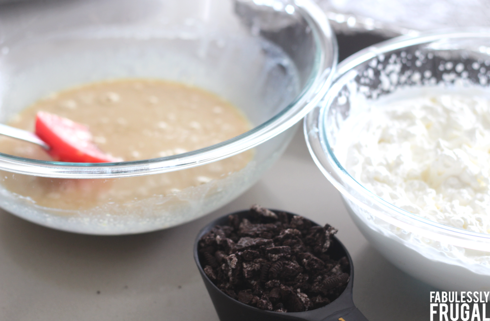 Whipped cream next to yolk mixture and oreo crumbles