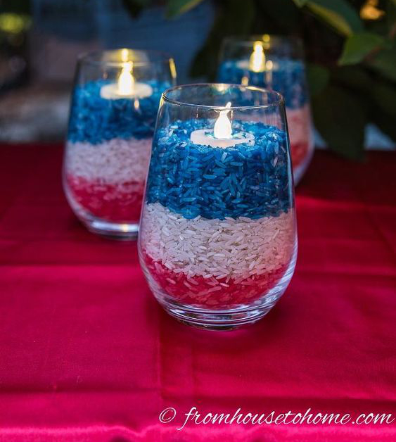 Red white and blue rice in a glass with a candle in the middle