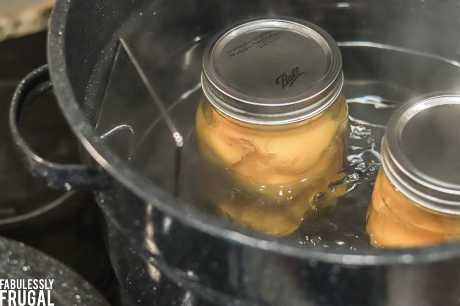 Cans of peaches in hot water bath