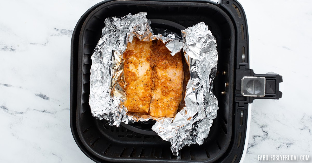 unwrapped tin foil asian salmon in air fryer basket