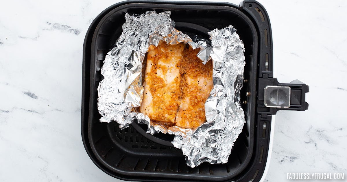 unwrapped tin foil asian salmon in air fryer basket