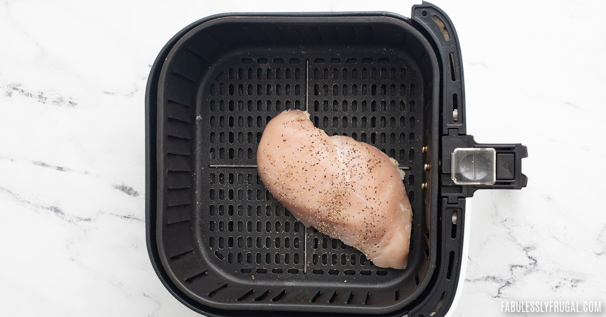 raw chicken breast in the air fryer basket