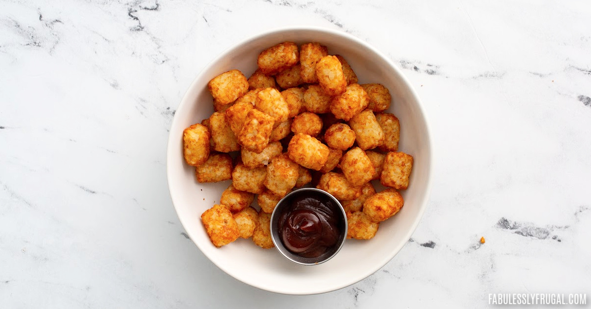 bowl of air fried tater tots with bbq sauce on the side