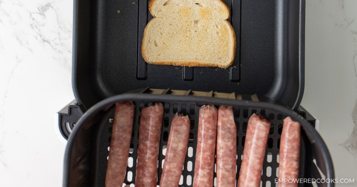breakfast sausage in air fryer basket with slice of bread