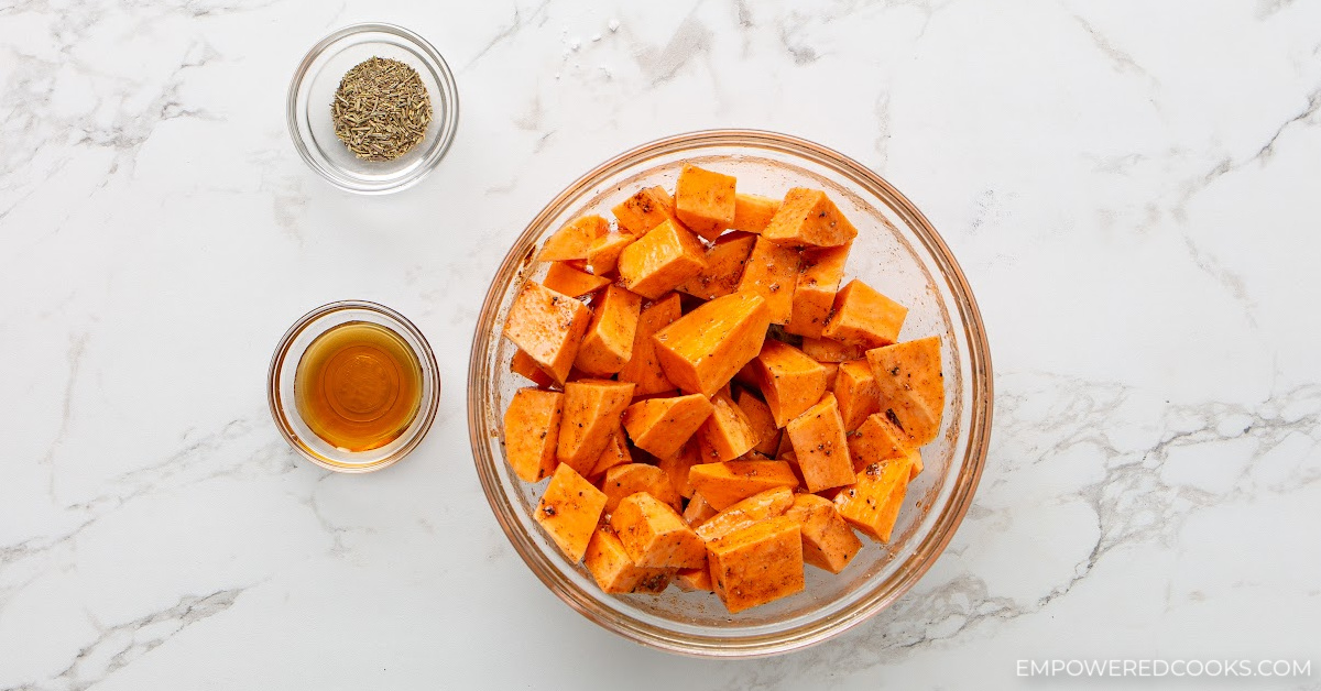 cubed sweet potatoes in bowl with seasoning